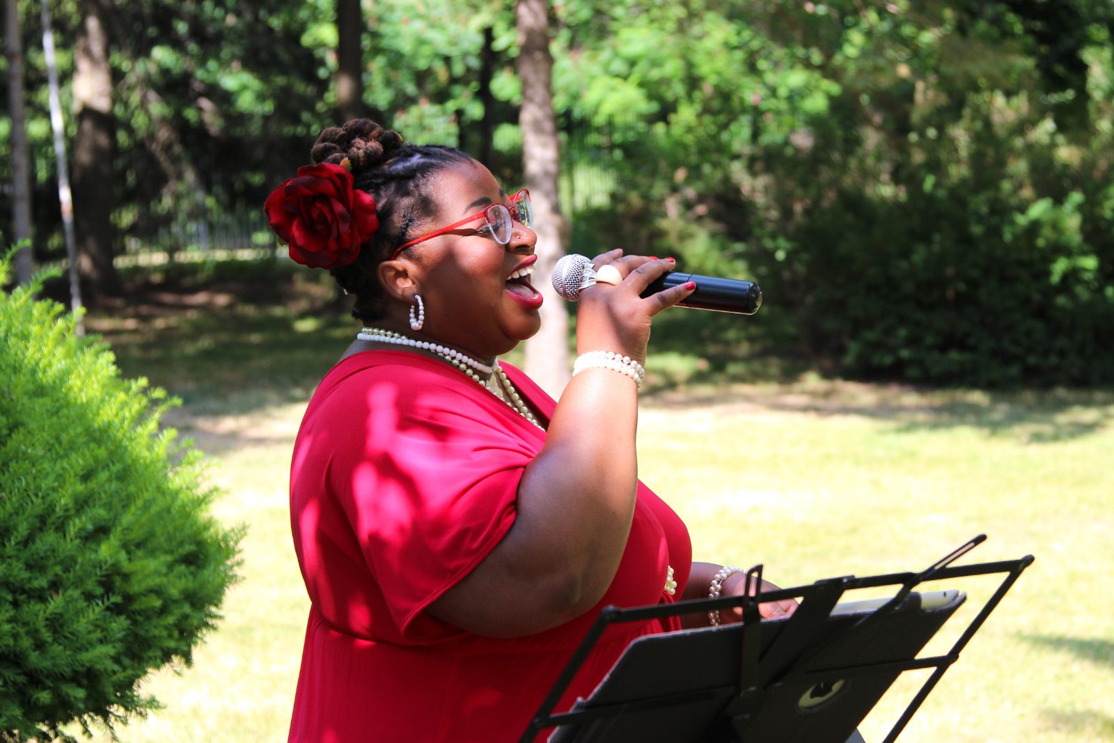 Carolyn T singing at an outdoor summer wedding ceremony